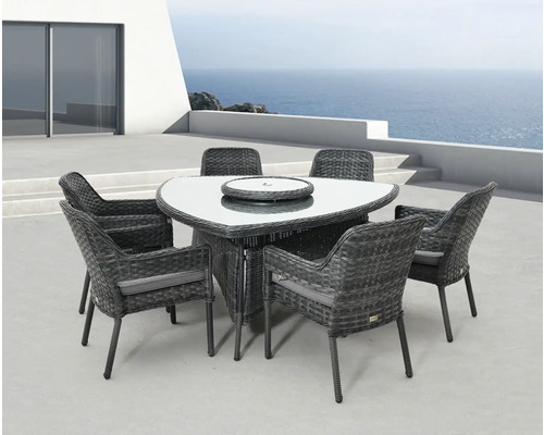 Zahradní nábytek se šesti židlemi, jídelní stůl se skleněnou deskou a ratanovým výpletem na terase s výhledem na moře