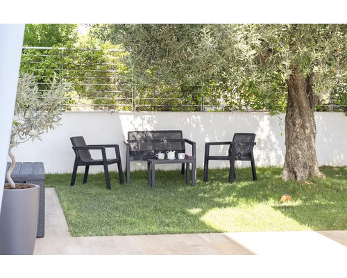 Zahradní nábytek na trávníku se židlemi a stolem pod stromem