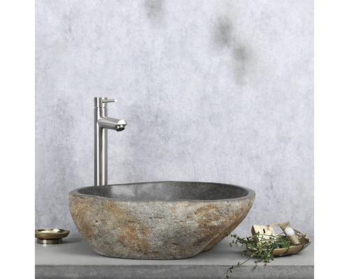 Umyvadlo z přírodního kamene s baterií na poličce s miskou na mýdlo a dekorací