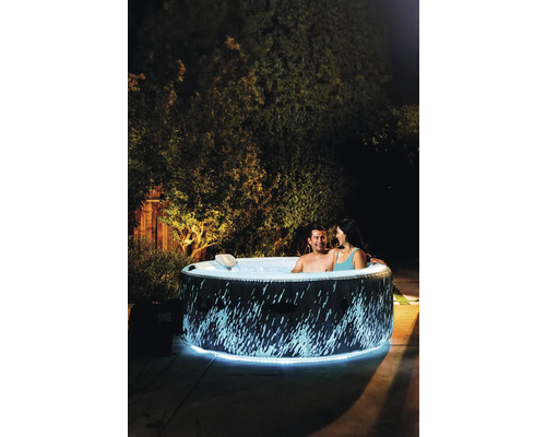 Nafukovací vířivka s osvětlením a dvěma lidmi na zahradě