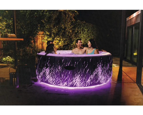 Nafukovací vířivka s osvětlením a několika lidmi na zahradě