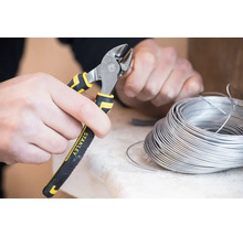 Osoba stříhá drát pomocí bočních štípacích kleští značky Stanley.