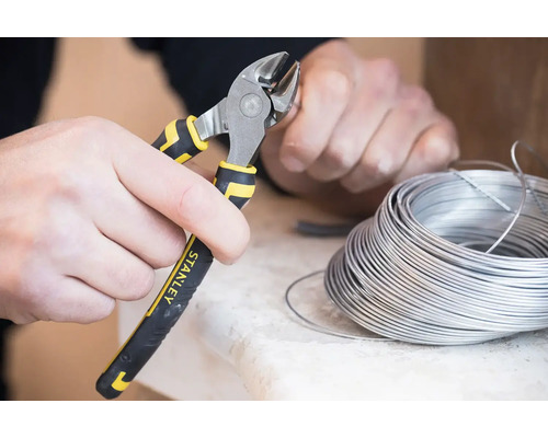 Osoba stříhá drát pomocí bočních štípacích kleští značky Stanley.