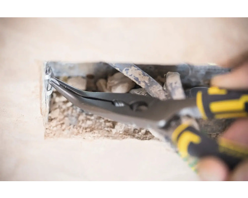 Kombinované kleště v provozu na otvoru ve zdi s kabely