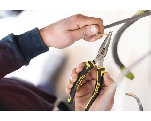 Osoba používá úzké kleště Stanley Fatmax ke stahování izolace z kabelu.
