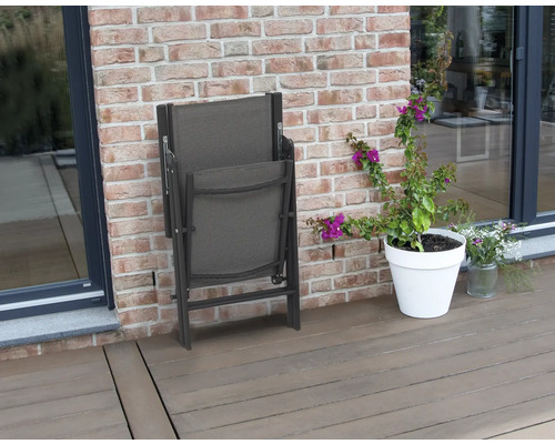 Skládací zahradní židle vedle květináče na terase