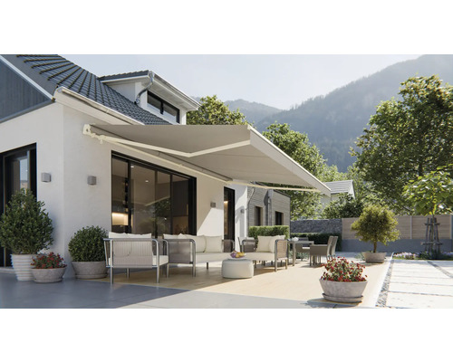 Fasáda domu s vysunutou markýzou a zahradním nábytkem na terase.
