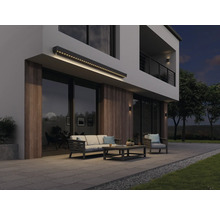 Moderní fasáda domu s osvětlenou markýzou, zahradním nábytkem a terasou