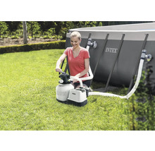 Žena obsluhuje pískovou filtraci Intex vedle bazénu