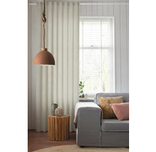 Obývací pokoj s šedou pohovkou, dřevěným bočním stolkem a látkovým závěsem