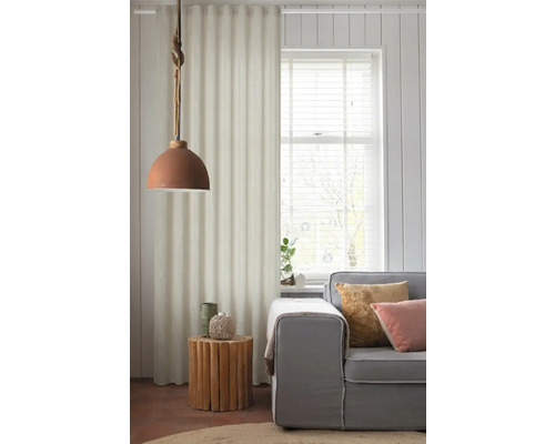 Obývací pokoj s šedou pohovkou, dřevěným bočním stolkem a látkovým závěsem