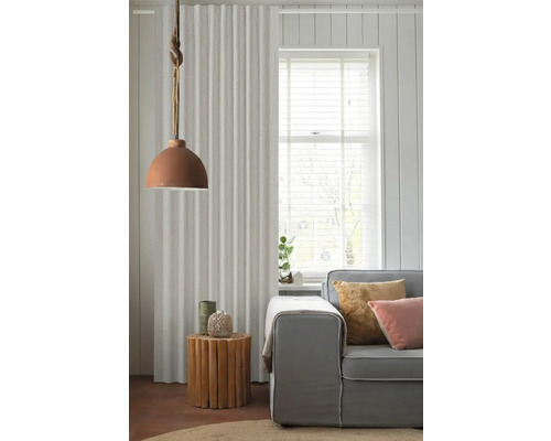 Obývací pokoj se závěsem, lampou, příručním stolkem a pohovkou pro útulnou atmosféru.