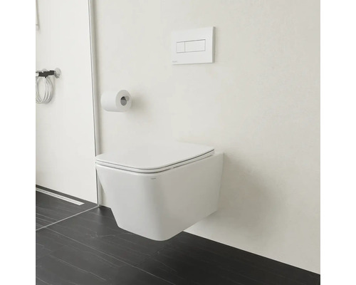 Závěsná toaleta s držákem toaletního papíru a ovládacím panelem v koupelně.