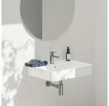 Umyvadlo s vodovodní baterií, zrcadlem a ručníkem v koupelně