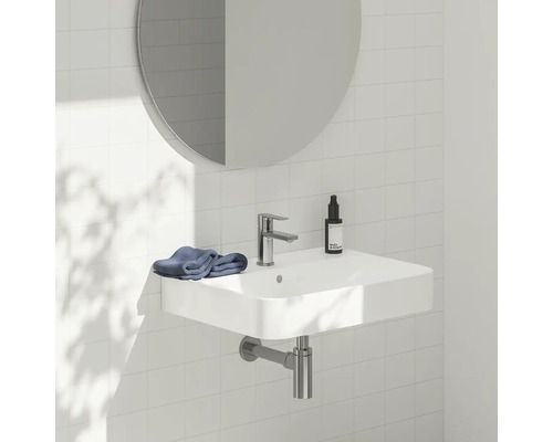 Umyvadlo s vodovodní baterií, zrcadlem a ručníkem v koupelně