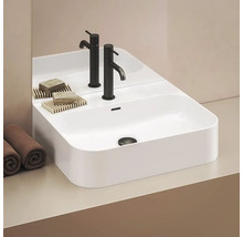 Moderní umyvadlo s bateriemi, mýdlem a ručníky v koupelně.