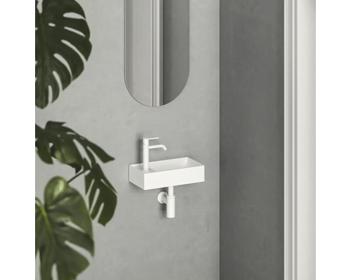 Malý umyvadlový prostor s bílým umyvadlem, baterií a zrcadlem