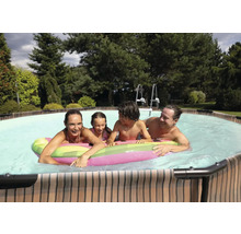 Rodina si užívá plavání v bazénu s žebříkem v zahradě.