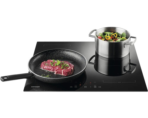 Indukční varná deska s steakem na pánvi a hrncem zeleniny