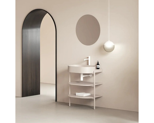 Koupelna s umyvadlem, kulatým zrcadlem, závěsným svítidlem a obloukovým dveřním otvorem