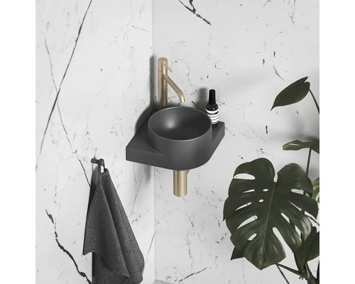 Koupelna s umyvadlem, baterií, ručníkem a pokojovou rostlinou