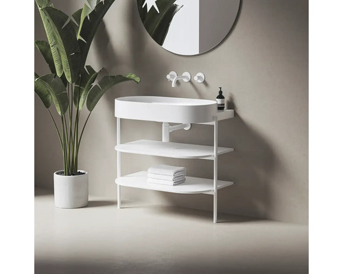 Bílé umyvadlo s úložnými policemi a baterií před zrcadlem a pokojovou rostlinou