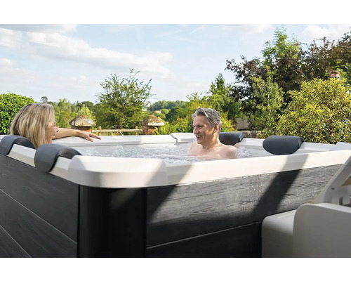 Dvě osoby relaxují ve venkovní vířivce.