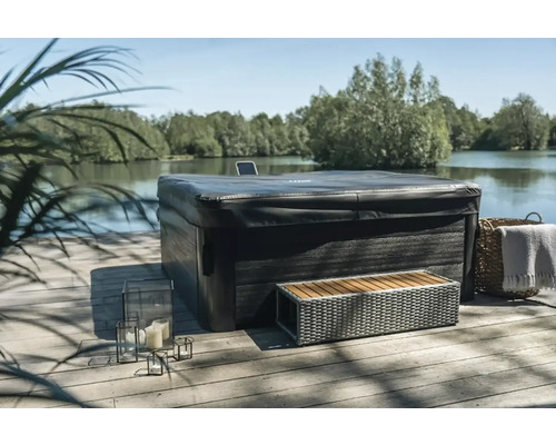 Zakrytá dřevěná vířivka s lavičkou a dekorací venku