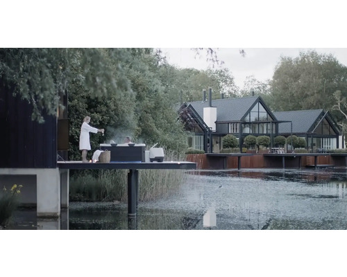 Scéna s vířivkou na plošině u jezera a domem v pozadí