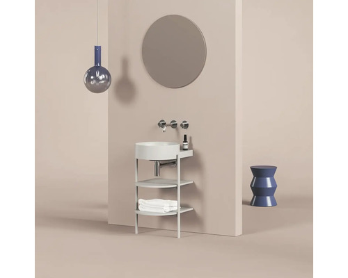 Koupelnové umyvadlo se zrcadlem, baterií, ručníky a dekorací na světle hnědém pozadí