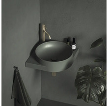 Rohové umyvadlo s baterií a držákem na ručníky v koupelně.