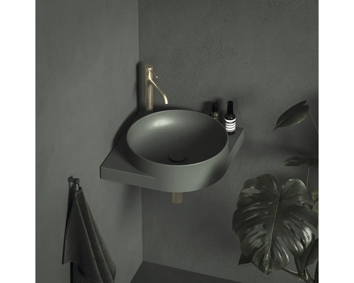 Rohové umyvadlo s baterií a držákem na ručníky v koupelně.