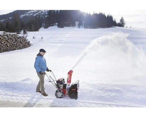 Osoba používá sněhovou frézu AL-KO k odklízení sněhu.