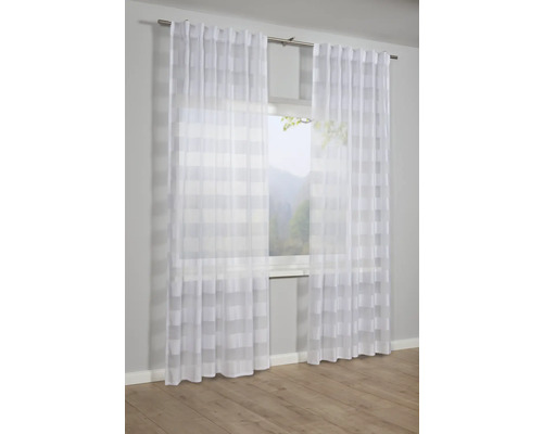 Okno s průhlednými bílými závěsy s proužkovaným vzorem