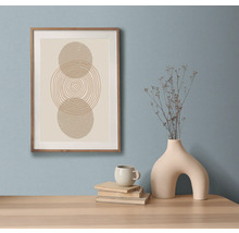 Dekorativní zátiší s uměleckým tiskem v rámu, knihami, šálkem a vázou na stole