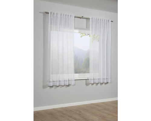 Okno se záclonami z průhledné látky.