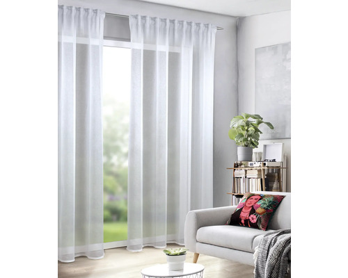 Obývací pokoj s bílými, průhlednými závěsy před oknem