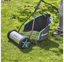 Ruční sekačka na trávu na trávníku se sběrným košem