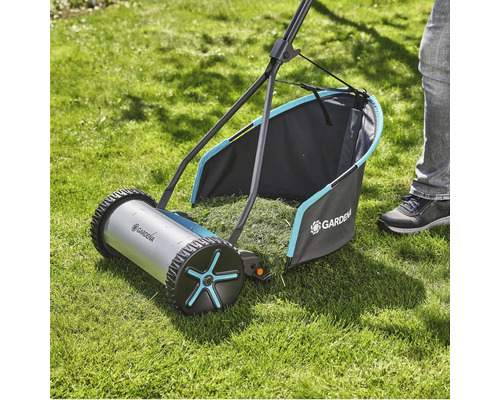 Ruční sekačka na trávu na trávníku se sběrným košem
