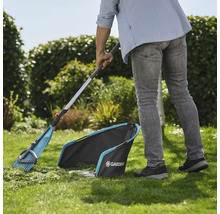 Zahradní scéna se zahradníkem zametajícím trávník hráběmi na listí a sběračem trávy od firmy Gardena