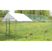 Venkovní výběh se sítí a několika kuřaty na louce.