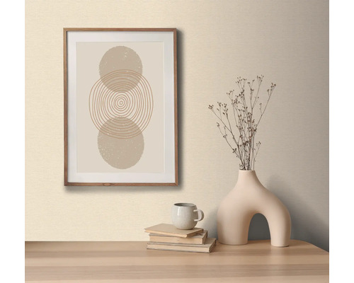 Dekorativní obrázek s kruhovým vzorem v dřevěném rámu, na stole s ozdobnou vázou a knihami