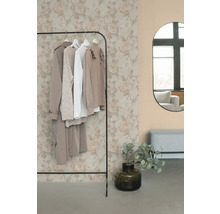 Stojan na oblečení s oblečením, zrcadlem a dekorací v místnosti.