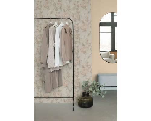 Stojan na oblečení s oblečením, zrcadlem a dekorací v místnosti.
