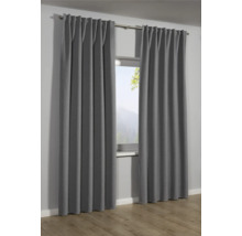 Šedé závěsy před oknem s výhledem na horskou krajinu.