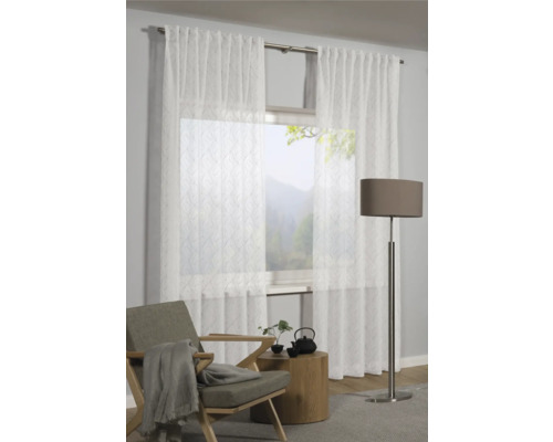 Scéna s průhlednými závěsy před oknem, křeslem, odkládacím stolkem a stojací lampou