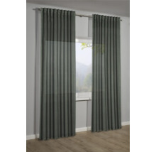 Dva závěsy před oknem s výhledem do přírody.