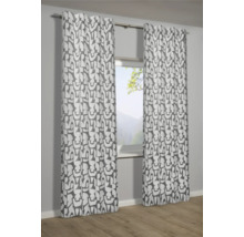 Dekorativní závěsy s grafickým vzorem před oknem.