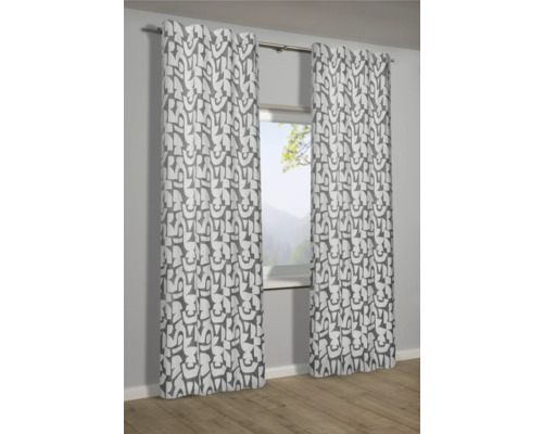 Dekorativní závěsy s grafickým vzorem před oknem.