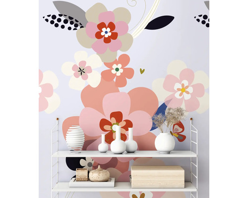 Police s dekorativními předměty před tapetou se vzorem květin